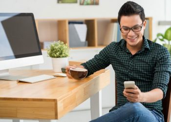 Handsome,Young,Man,Drinking,Coffee,And,Reading,A,Message,On