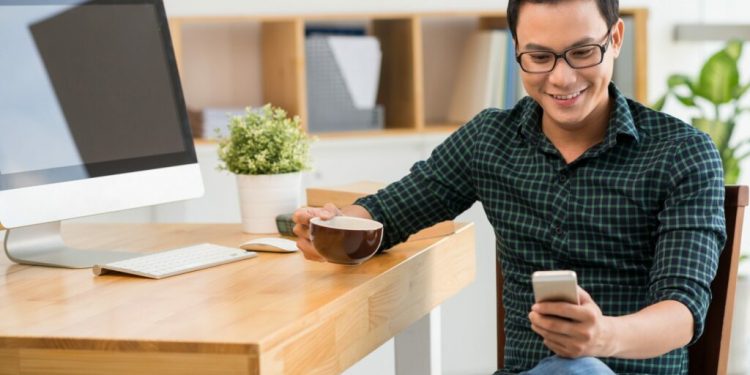 Handsome,Young,Man,Drinking,Coffee,And,Reading,A,Message,On